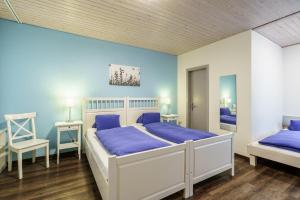 1 dormitorio con 2 camas y paredes azules en Hotel Alphorn en Interlaken