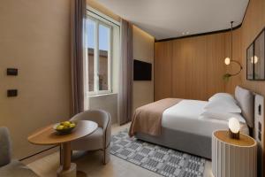 a hotel room with a bed and a table at Six Senses Rome in Rome