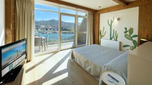 une chambre avec un lit et une grande fenêtre dans l'établissement Fronte Mare Suites - ArgonautiVacanze, à Portoferraio