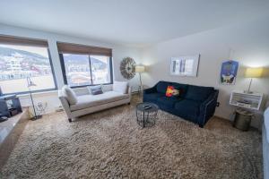 a living room with a blue couch and a chair at Edgewater 1436 in Keystone
