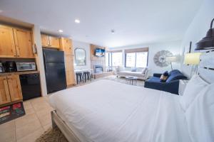 a bedroom with a large white bed and a kitchen at Edgewater 1436 in Keystone