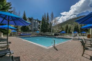 a swimming pool with chairs and umbrellas at Edgewater 1436 in Keystone
