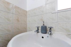 um lavatório branco com um dispensador de sabão em Comfy & Homely Ideal for Families & Contractors em Darlington