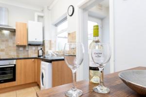 達靈頓的住宿－Comfy & Homely Ideal for Families & Contractors，桌子上放有一瓶葡萄酒和两杯酒