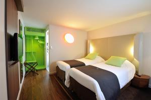 オランジュにあるCampanile Orange A7/ A9のベッド2台、薄型テレビが備わるホテルルームです。