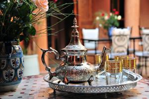 a tea pot on a tray with glasses on a table at Riad Bensaid in Marrakesh