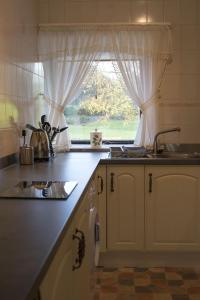 uma cozinha com um lavatório e uma janela em Grange Cottage Lakeside Windermere em Newby Bridge