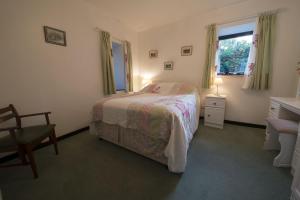 um quarto com uma cama, uma secretária e uma janela em Grange Cottage Lakeside Windermere em Newby Bridge