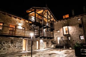 un grand bâtiment en pierre avec un balcon dessus la nuit dans l'établissement LA CORTE ANTEY - Pilier, à Antey-Saint-André