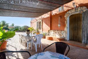een patio met een tafel en stoelen bij Hauzify I Mas Bomba in Les tres Cales