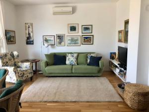 a living room with a green couch and a television at Villa Mimy in Ugljan