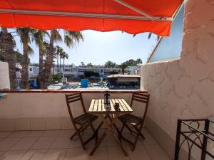 a table and chairs on the balcony of a restaurant at Sunny terrace, fast WiFi relax & remote work quiet area in Arona