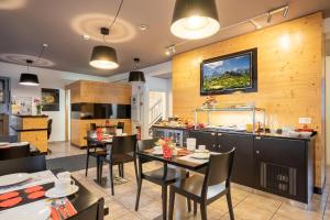 a kitchen and dining room with tables and chairs at Hotel Alphorn in Interlaken