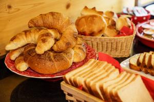 a table topped with plates of pastries and baskets of bread at Hotel Alphorn in Interlaken