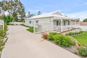 a white house with a garden and a driveway at Cooma Luxe in Cooma