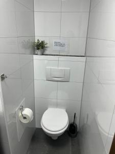 a white bathroom with a toilet and a sink at Ferienwohnung Emilia in Cologne