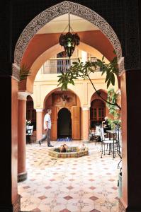 an archway in a building with a dog laying in a fountain at Riad Bensaid in Marrakech