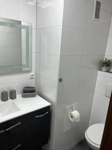 bagno bianco con servizi igienici e lavandino di Ferienwohnung Emilia a Colonia