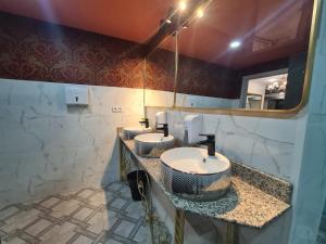 a bathroom with three sinks and a mirror at Almaty Grand Erbil Hotel in Almaty