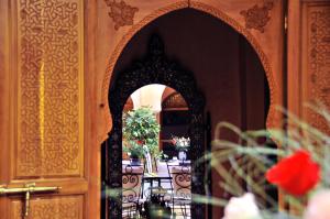 uma porta ornamentada para uma sala de jantar com uma mesa em Riad Bensaid em Marrakech