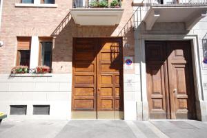 une paire de portes en bois sur un bâtiment dans l'établissement Lovely 1-Bedroom Apartment in Lingotto Area, à Turin
