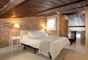 バルセロナにあるAB Poble Nou Veneroのレンガの壁、大きなベッド付きのベッドルーム1室