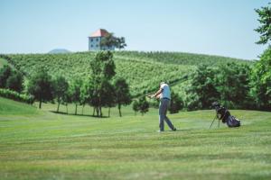 a man playing with a dog on a golf course at Wine Grower's Mansion Zlati Gric in Slovenske Konjice