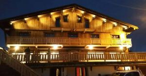 a large wooden building with lights on the balcony at Appartement Le Pic in Samoëns