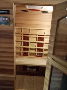 a sauna with wooden panels and a clock on the wall at Appartement Le Pic in Samoëns