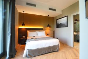 Un dormitorio con una cama grande en una habitación. en Villa Carla Suites in Barolo, en Barolo