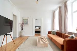 a living room with a couch and a tv at Bright Apartment in the Old Town of Copenhagen in Copenhagen