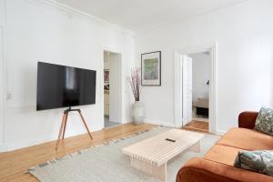 a living room with a couch and a flat screen tv at Bright Apartment in the Old Town of Copenhagen in Copenhagen