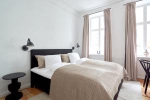 a white bedroom with a large bed with white sheets at Bright Apartment in the Old Town of Copenhagen in Copenhagen +27 photos