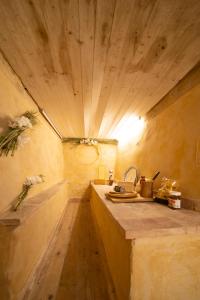 La salle de bains est pourvue d'un lavabo et d'un plafond en bois. dans l'établissement VILLA ALTA ECO&LUXURY, à Provaglio d'Iseo
