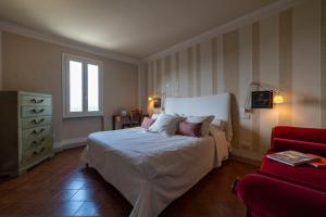 - une chambre avec un grand lit et un canapé rouge dans l'établissement VILLA ALTA ECO&LUXURY, à Provaglio d'Iseo