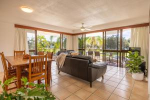 a living room with a couch and a table at Coastal SOL -Right on Clarkes Beach! in Byron Bay