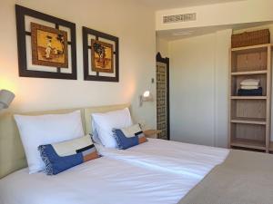 ein Schlafzimmer mit einem großen weißen Bett mit blauen Kissen in der Unterkunft Luxe Haciënda La Campiña met verwarmd zwembad en tennisbaan. in Alhaurín el Grande + 43 Fotos