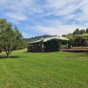 ein Haus inmitten eines Grasfeldes in der Unterkunft The Hammock 