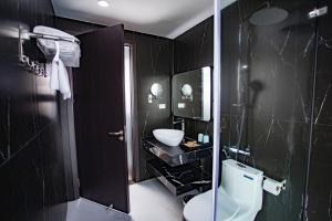 a black bathroom with a toilet and a sink at La Maison Boutique Hotel in Cao Bằng