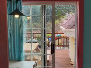 a room with a large glass door to a balcony at Olive Vanilla Pension in Gyeongju