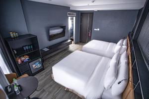 a bedroom with a white bed and a tv at La Maison Boutique Hotel in Cao Bằng