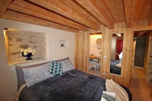 une chambre avec un lit dans une pièce avec des plafonds en bois dans l'établissement LA CORTE ANTEY - Pilier, à Antey-Saint-André 16 autres photos