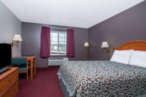 a hotel room with a bed and a television at Days Inn by Wyndham Fargo/Casselton in Casselton +17 photos