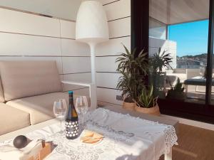 una mesa con dos copas y una botella de vino en CANELAS SUITES PREMIUM NUEVOS con PISCINA, AMPLIAS TERRAZAS Y GARAJE en Portonovo