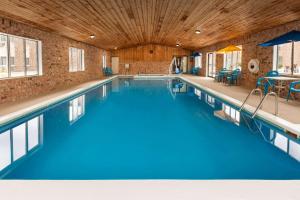 - une piscine d'eau bleue dans un bâtiment dans l'établissement Baymont by Wyndham Manistee, à Manistee