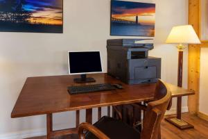 a desk with a computer and a printer on it at Baymont by Wyndham Manistee in Manistee