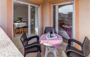 a balcony with a table with wine glasses and chairs at Lovely Apartment In Medulin With Kitchen in Medulin