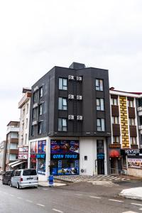 a black building with cars parked in front of it at QZEN SUİT APART OTEL in Trabzon