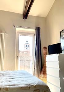 Schlafzimmer mit einem Bett und einem Fenster in der Unterkunft Casa Al convento in Savigliano
