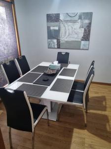 a dining room table with chairs and a black and white table at WI -FI- Netflix- Super Comfiest 3 Bedroom Home With Massive 21Metre Driveway Space for boat & Caravan in Portland